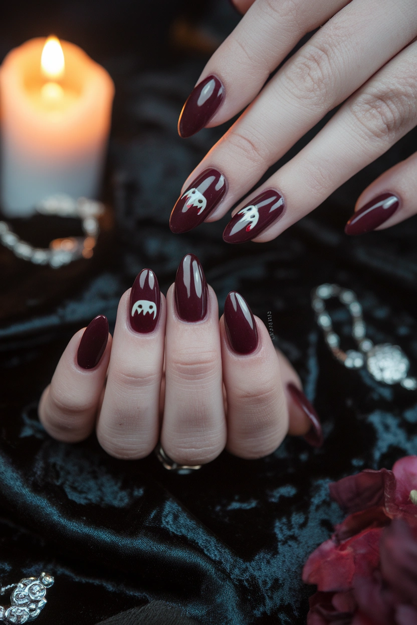 Vampire Bite Nail Art Image Prompt: Halloween manicure featuring glossy deep burgundy nails with tiny vampire bite accents, two small white fang marks and red details, medium almond shape, black velvet background, warm candlelight, subtle silver jewelry, clean cuticles, realistic salon photography, elegant gothic Pinterest aesthetic.